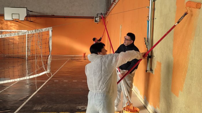 la scuola e chiusa per le vacanze i docenti ridipingono i muri della palestra