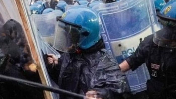 coisp manifestanti colpiscono i poliziotti usando la bandiera della pace