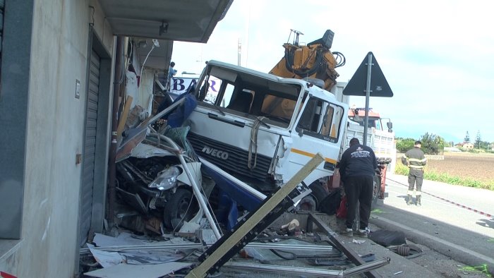 tragedia sfiorata scontro auto camion veicolo schiacciato e negozio distrutto