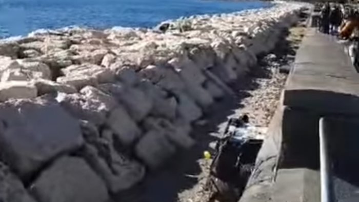 napoli sugli scogli del lungomare spunta la baracca di un clochard