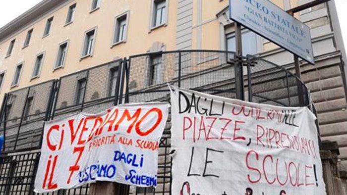 protesta con striscioni fuori alle scuole