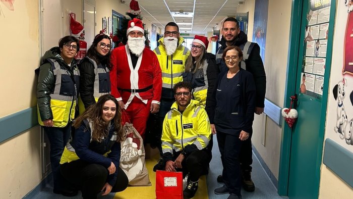 i volontari della protezione civile consegnano doni ai pazienti di pediatria