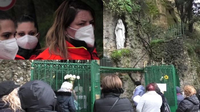 pellegrini e volontari davanti alla grotta di lourdes