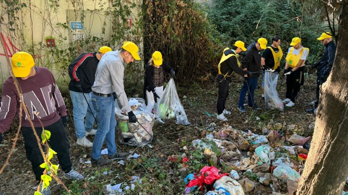 la strada della scuola e piena di spazzatura gli studenti la ripuliscono